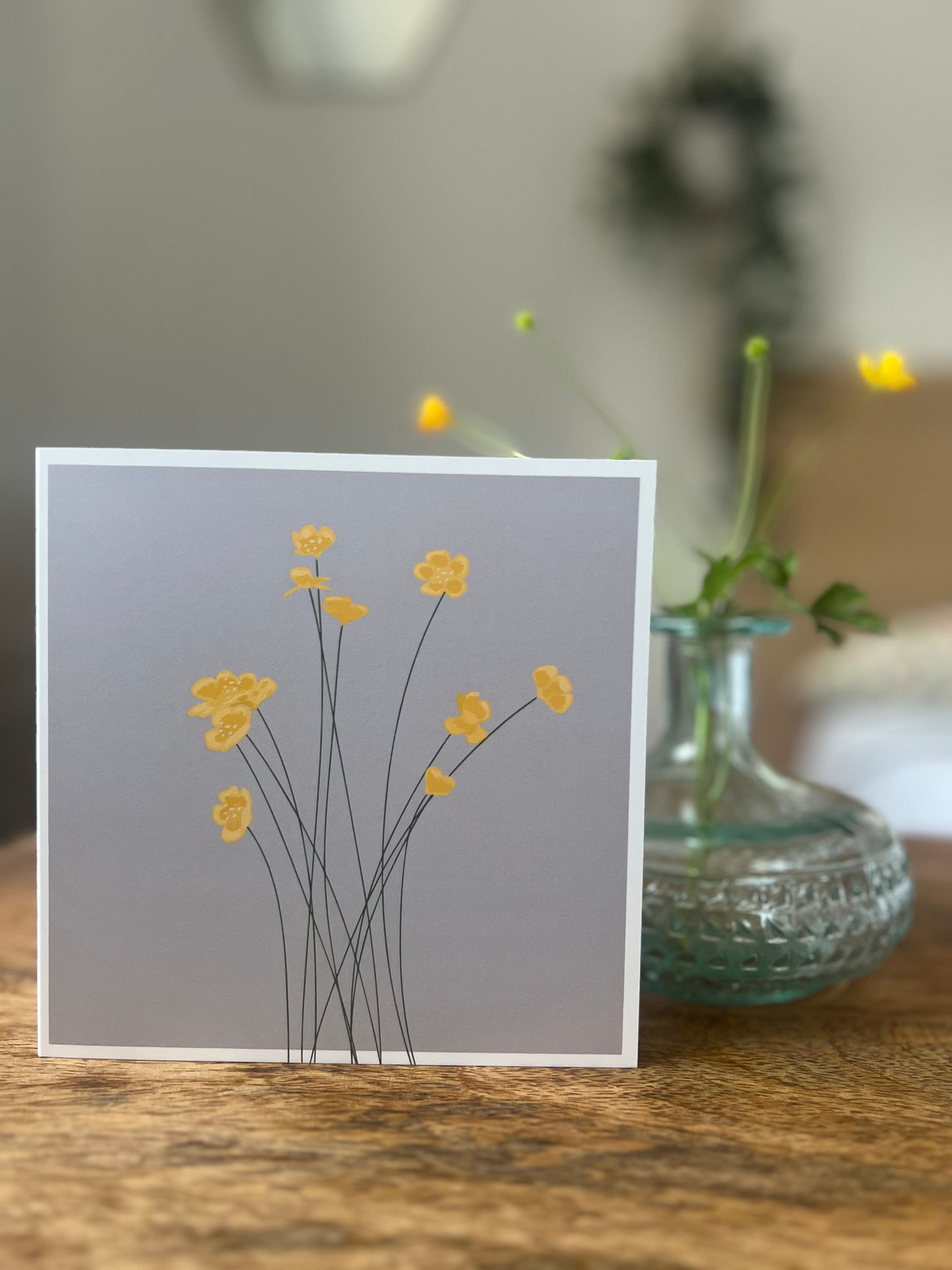 Yellow buttercup greetings card on grey background